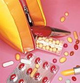 Pillen liegen verstreut neben einem Schminktäschchen und Lippenstift