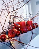 Close-up of mantelpiece decorated with apples and lit candles for Christmas