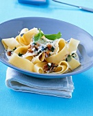 Ribbon pasta with herbs, walnut and cream in serving dish