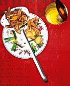 Salad with roasted duck and lychees on plate and frying spoon