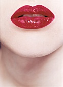 Close-up of woman lips wearing red glossy lipstick