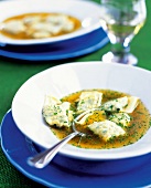 Close-up of spinach filling trout soup with ravioli kept in bowl