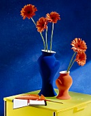 Gerberas in zwei Vasen, rot und blau X.
