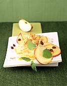 Apfelpfannkuchen mit frischen Apfelscheiben und Rosinen dekoriert