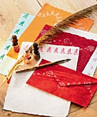 Close-up of hand made envelopes with feather, ink pot and fountain pen