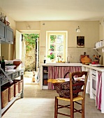 View of kitchen with French style chair standing in middle of room