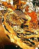 Close-up of gold bullion on golden foil