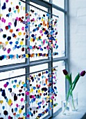 A multi-coloured beaded curtain against window