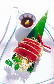 Close-up of tuna in black pepper coating on white plate