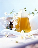 Close-up of almond oil and aromatic oil bottles surrounded with jasmine flowers around