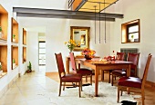 Dining room with dining table, chair, flower vase and hanging lamps