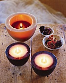 Lit scented floating candles with dried flowers in bowls