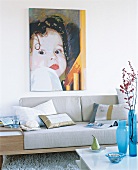Painting of child hanging over sofa in living room