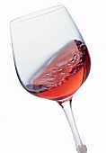 Rotwein im Rotweinglas in Bewegung entfaltet Bukett, Freisteller