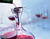 Red wine being decanted through funnel