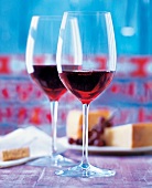 2 Gläser mit Rotwein vor Teller mit Käse, Still