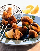 Fried mushrooms in crispy pastry with lemon on plate