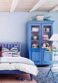 Schlafzimmer in blau  Bett und Schrank aus Holz, rustikal