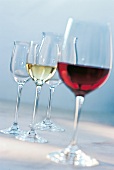 Mehrere Weingläser, je ein Glas mit Rot- bzw. Weißwein gefüllt