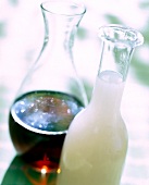 Close-up of bottle with almond syrup and flask with amaretto
