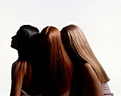 Three women with long straight hair of blonde, red and dark brown colour