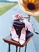 Grammophon,rosa Handschuhe & Schuhe auf antikem Tisch