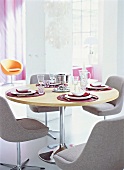 Laid dining table with fondue set and four gray chairs