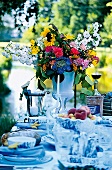 bunter Blumenstrauss als Tischdeko, gedeckter Tisch, außen, Sommer