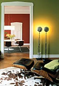 Altbauwohnung, Wohnzimmer, Wand grün Lounge Chair, Teppich aus Kuhfell