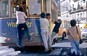 Kinder hängen sich in Lissabon an Straßenbahn.