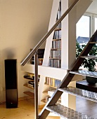 Room with sloping CD rack with shelves and steel staircase