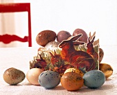 Hare family sitting on grass of paper with speckled Easter eggs around