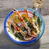 Grilled scampi with lemon on plate beside vinaigrette