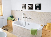 Badezimmer nach Umbau, helle Fliesen Badewanne, Bilder an der Wand