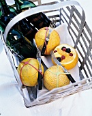 Fruit salad in galia melon with fork and wine bottles in basket