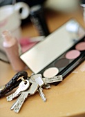 Eye shadow palette and key chain on table
