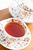 Floral pattern cup and saucer with tea