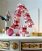 Christmas tree made of small red and white boxes with lit candles