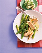 Pieces of chicken breast and green asparagus on plate