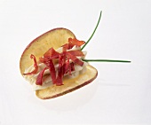 Close-up of apple chips with double cream and ham on white background