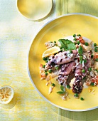 Rice with squid on yellow plate with squeezed lemon on table