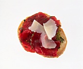 Close-up of baguette appetizers with carpaccio, beef pesto and basil on white background