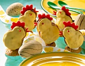 Marzipan chick with eggs and plates with green spoons on table