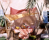 Oriental board under the canopy wicker chairs and silk tablecloth