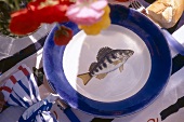 Ceramic plate with blue border and fish decor