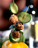 Close-up of skewers with meatballs and cucumber