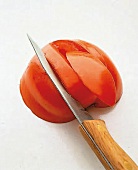 In die Tomate werden Kerben geschnitten