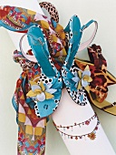 Floral sandals, scarf and necklace on white background