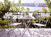 White metal chairs on terrace by water