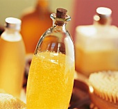 Close-up of yellow bath gel in bottle with cork